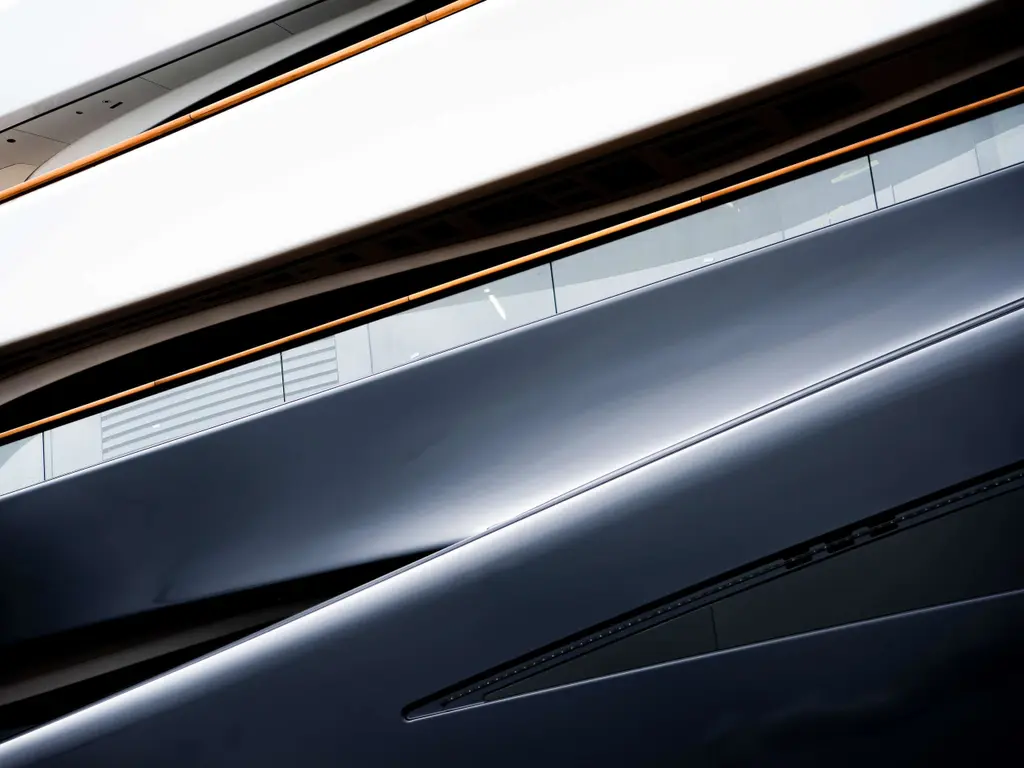 Abstract detail of Breakthrough's hull and superstructure lines with teak capping rails