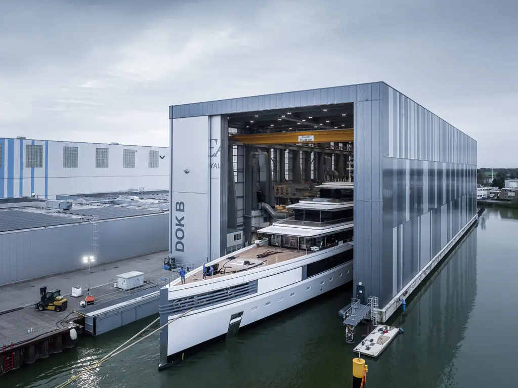 Ulysses at the open doors of the covered dock hall, her bow outside and her upper decks inside, seen from above