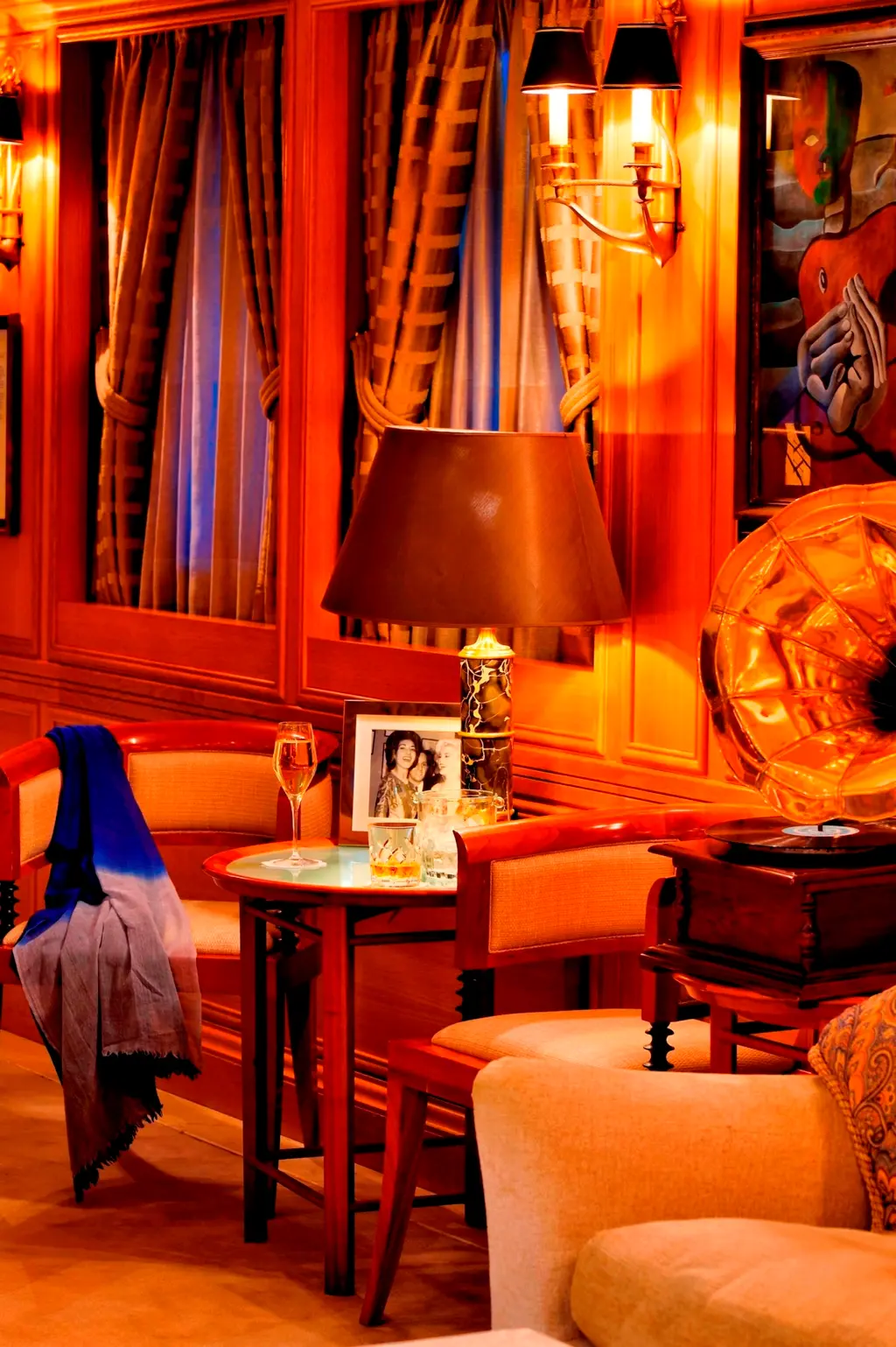 Lounge corner with wood panelling, a table lamp, a framed photograph and a gramophone