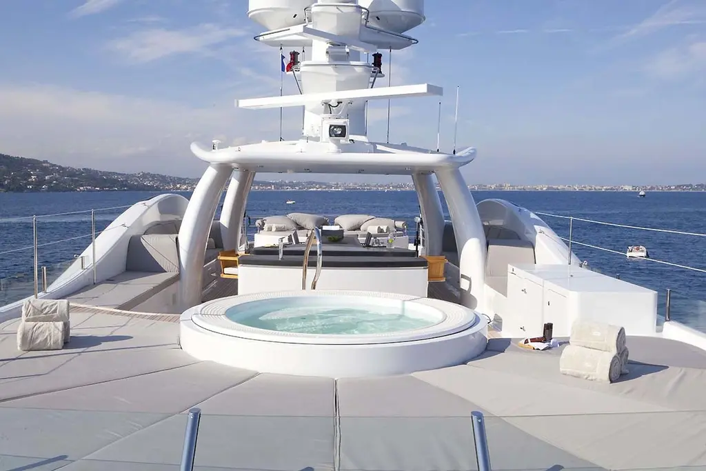 Round Jacuzzi on the sun deck, with sunpads under the mast
