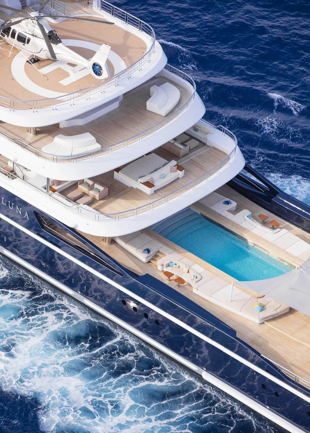 Aerial view of Luna's aft helipad with a helicopter, the stepped decks and the swimming pool