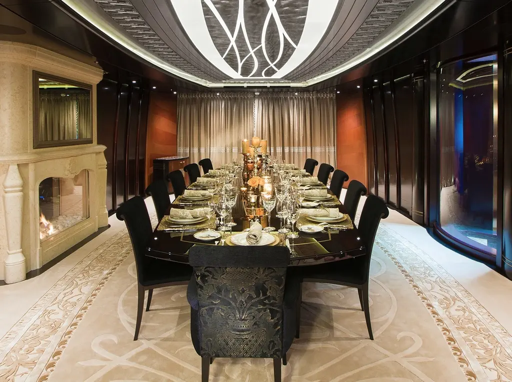 Formal dining room with a long table and a sculpted ceiling light