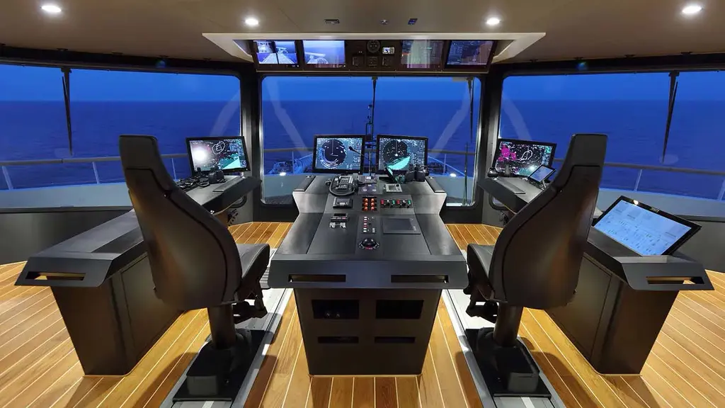 Bridge with two helm chairs, a central console and wide forward windows