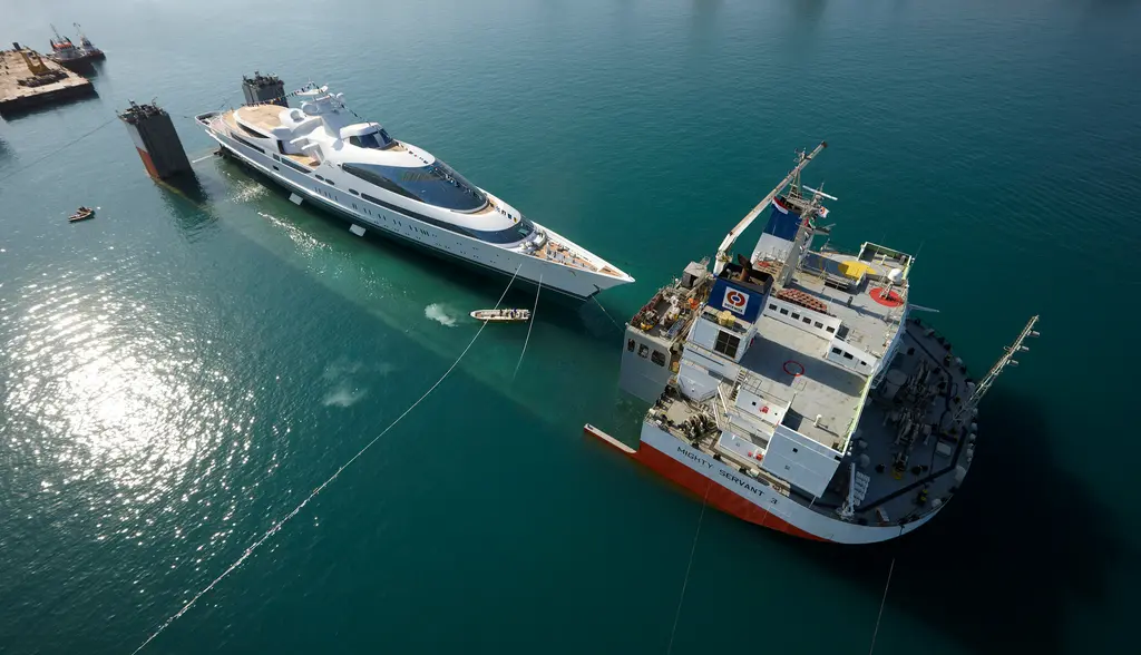 Aerial view of Yas afloat beside the semi-submersible heavy-lift ship Mighty Servant 3, with a small tender between them