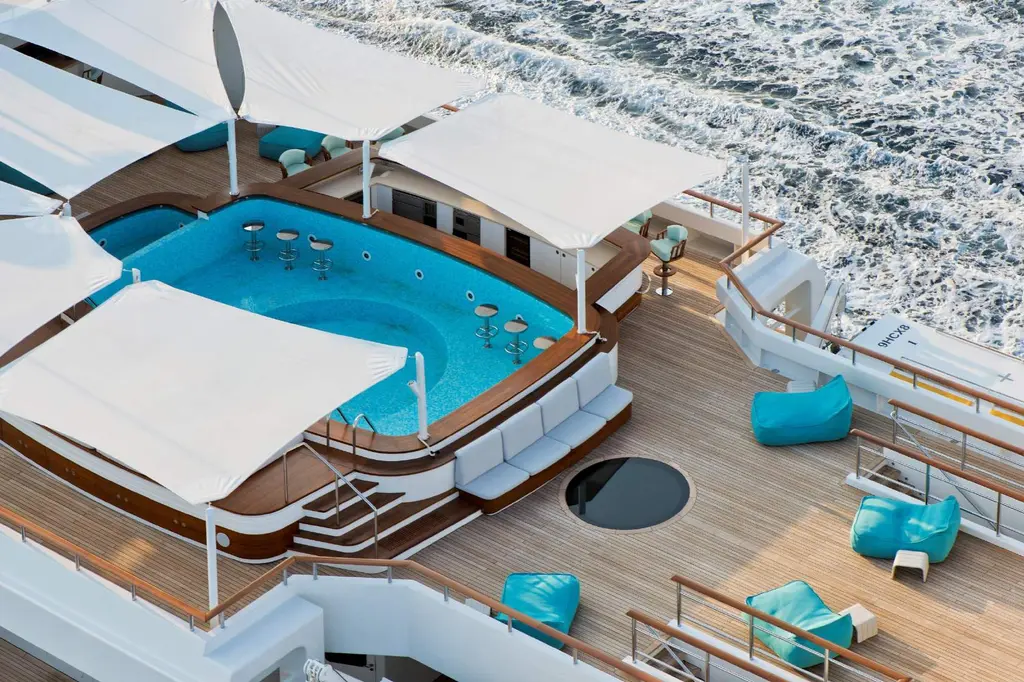 Aerial view of the sundeck pool with swim-up stools under white shades