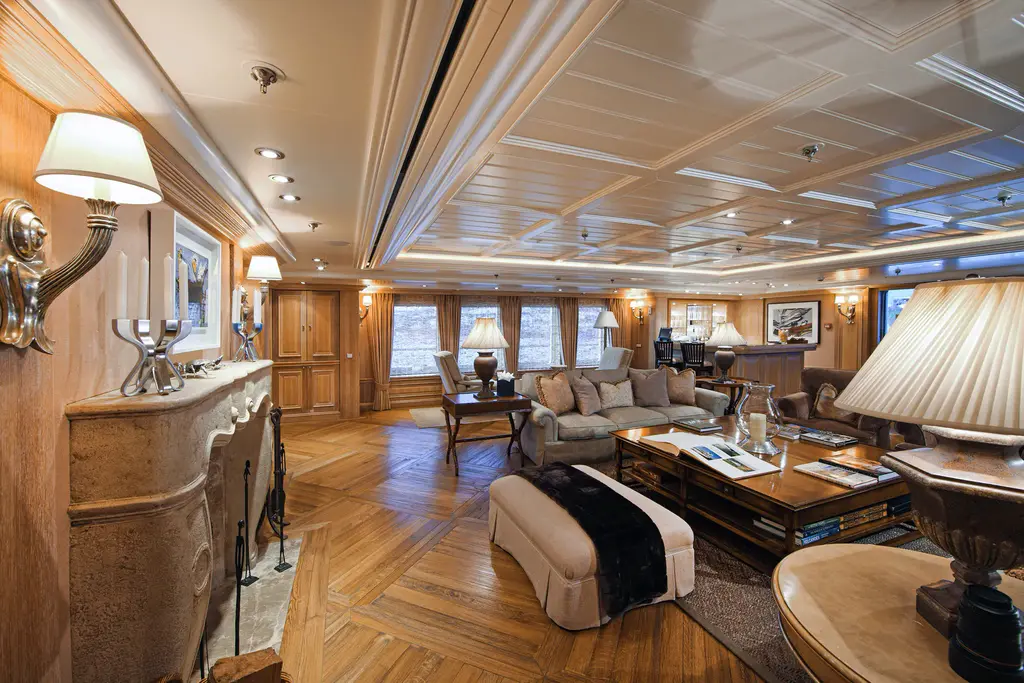 Salon with parquet floor, coffered ceiling, stone fireplace and sofas
