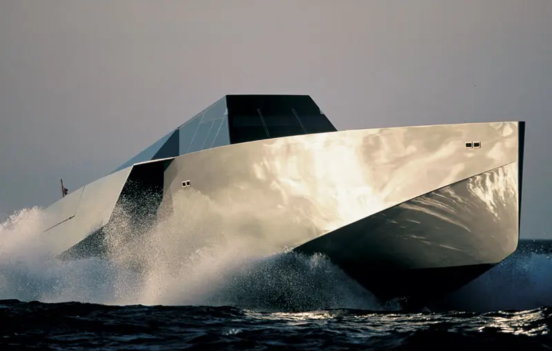 Close view of the Wallypower 118's knife-edged bow throwing spray, the faceted deckhouse above