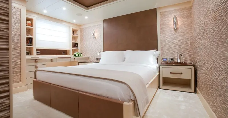 Guest cabin with a double bed, padded headboard and bookshelves