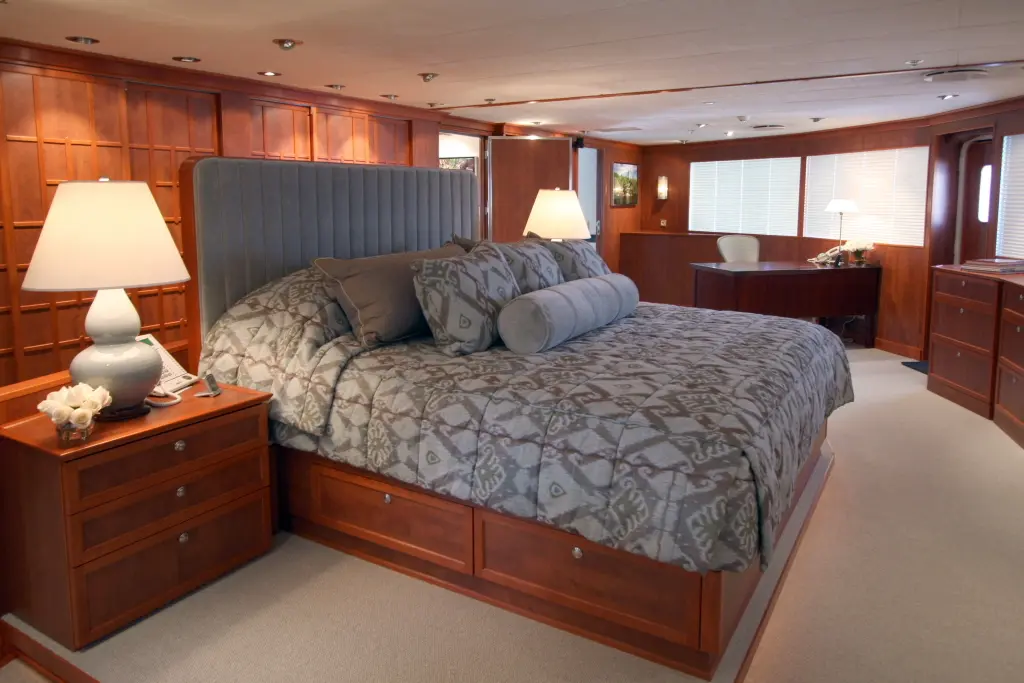 Double cabin with a patterned bedspread, wood-panelled bedside tables and lamps