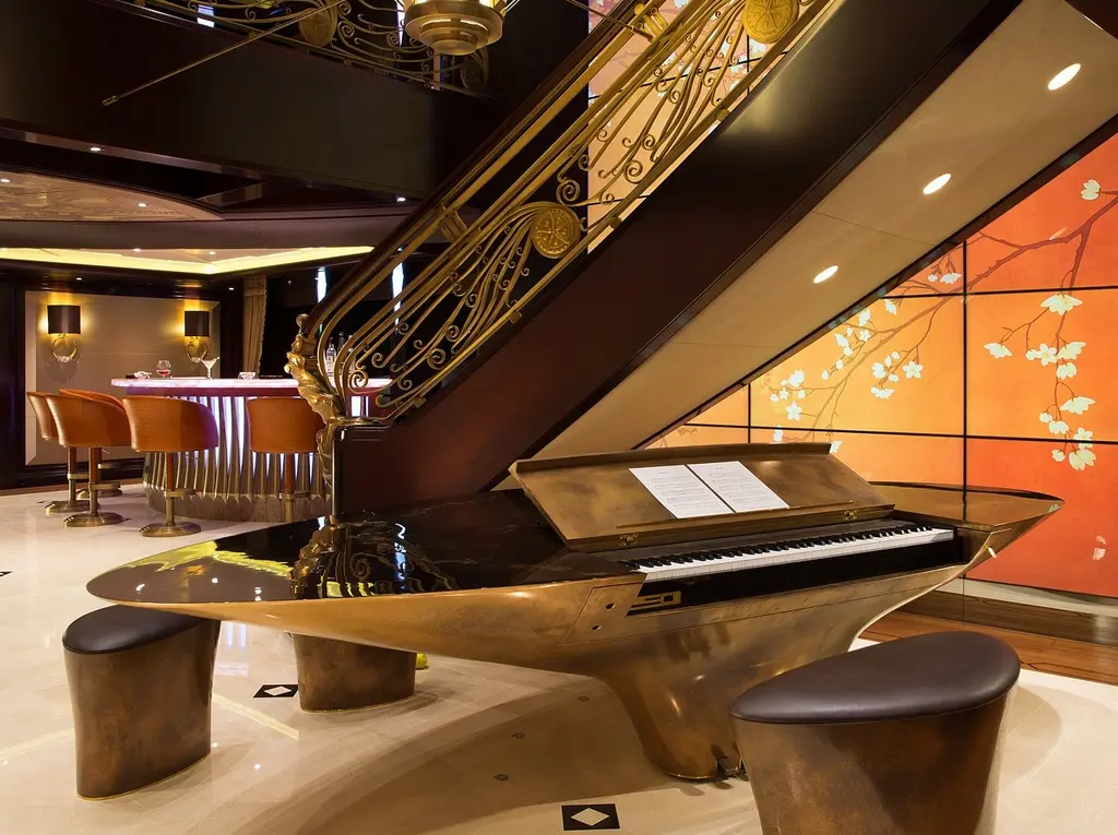 Sweeping staircase in the main salon with a custom piano at its foot