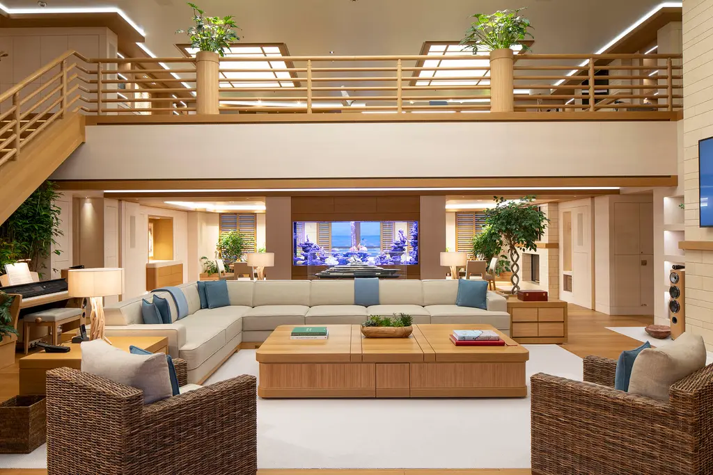 Double-height saloon with a gallery above and an aquarium behind the sofa