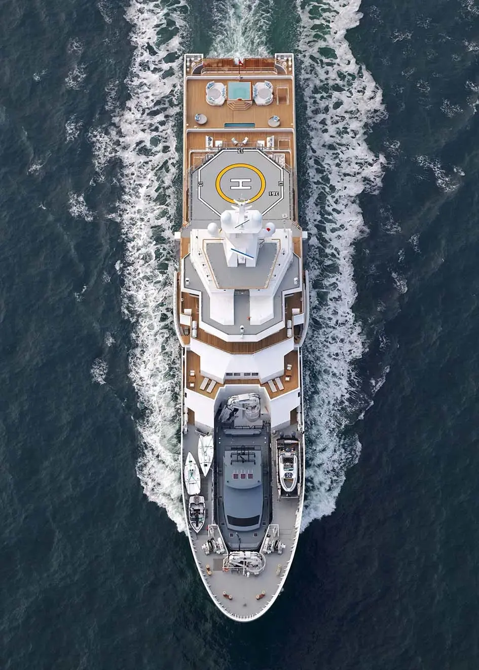 Overhead view of Andromeda under way, showing the aft pool deck, the helipad and tenders stowed on the foredeck