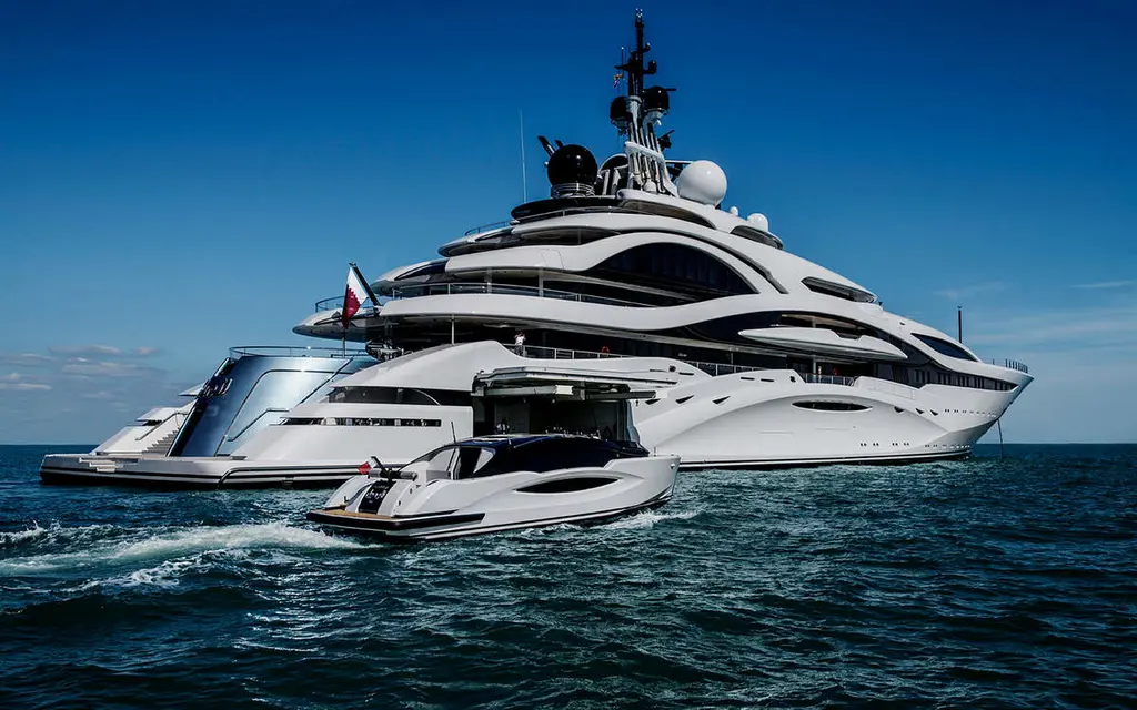Al Lusail at sea from the stern quarter, a white limousine tender running alongside