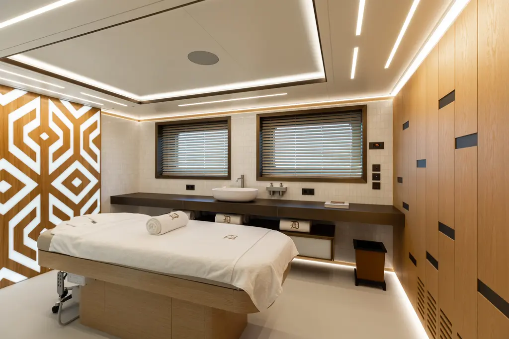 Massage room with a treatment table, wooden walls and a geometric patterned panel