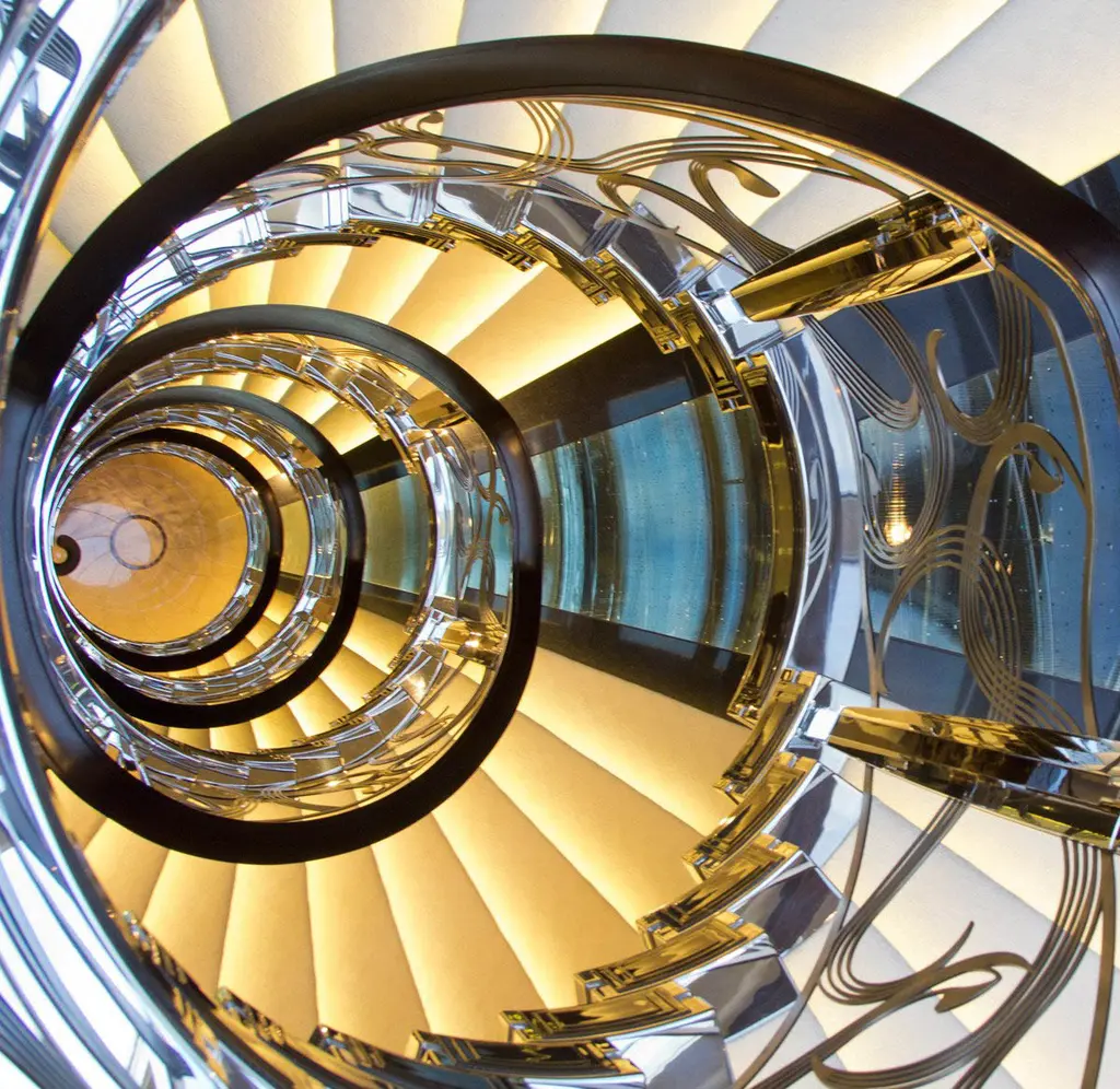 Looking up the spiral staircase of Serene with a glass and metal balustrade