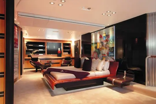 Owner’s suite with a large bed, a desk area and a colourful painting on the wall