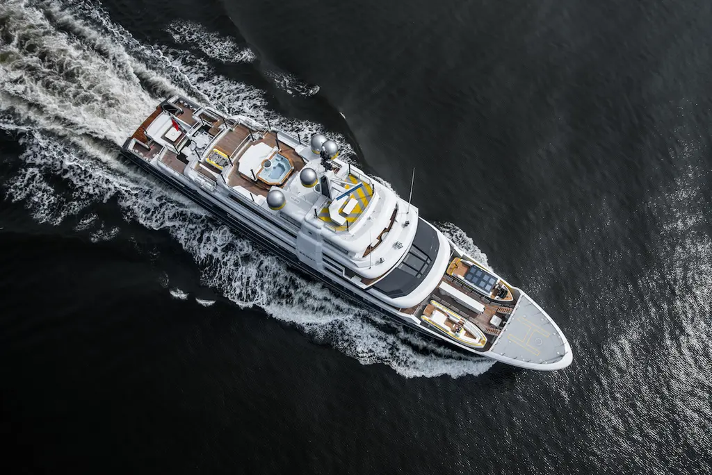 Aerial view straight down on Scout under way, showing the raised helideck forward, the open sundeck with its spa pool and the teak aft decks