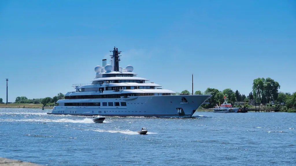 Scheherazade underway on a river under a clear blue sky, two small boats passing in front