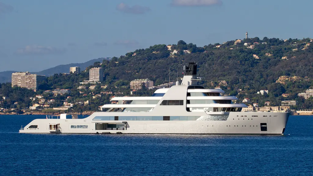Solaris at anchor off a wooded hillside with apartment blocks and villas behind