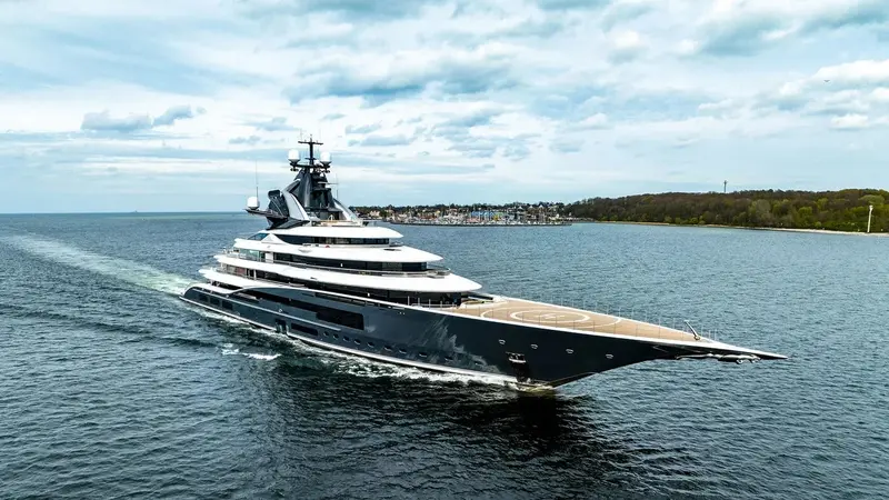 Kismet at sea, dark blue hull with white superstructure and helipad on the bow