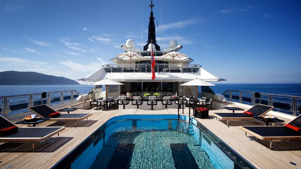 Aft deck with the pool and sun loungers, the bar and superstructure behind