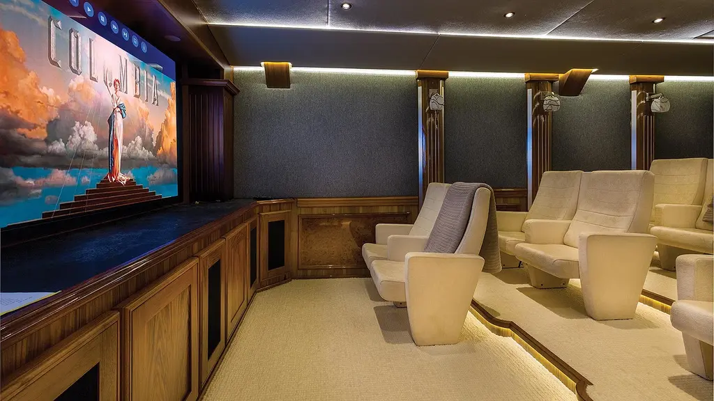 Cinema with cream armchairs facing a large screen