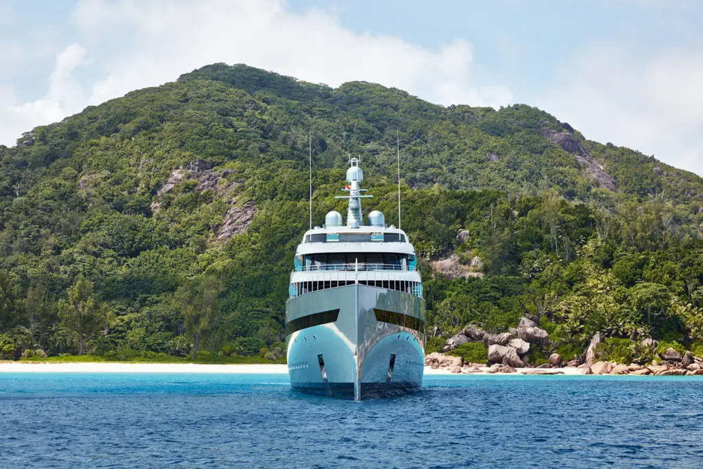 Savannah seen head-on at anchor, the plumb bow in front of a wooded hillside