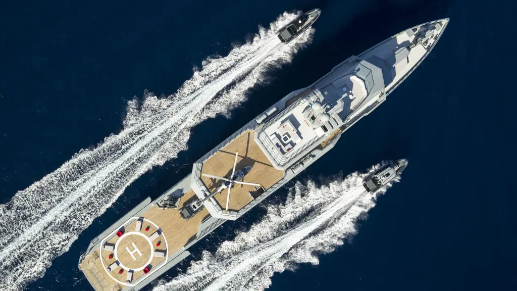 Overhead view of Bold under way between two of her tenders, each leaving a white wake, with the helipad on the aft deck