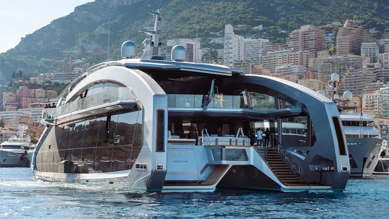 This Is It in Monaco harbour seen from the stern quarter, two silver hulls with curved glass and an open aft deck between them