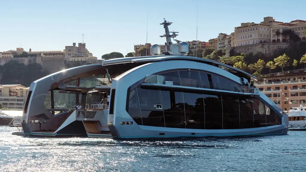 This Is It underway off Monaco, side view of a hull wrapped in dark glass under a silver arch