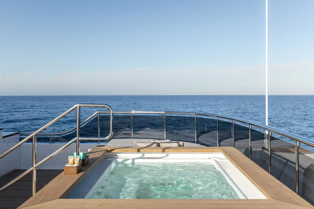 Spa pool on the sun deck with the open sea beyond the rail