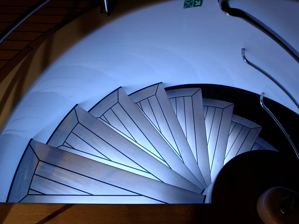 Looking down a spiral staircase with backlit steps
