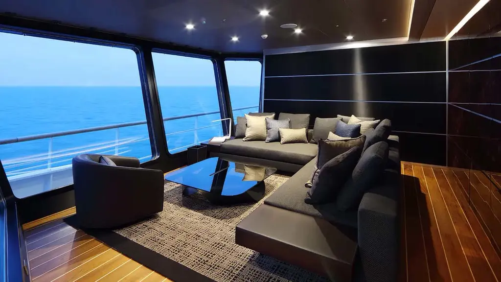 Lounge with a dark sectional sofa and sea views through large windows