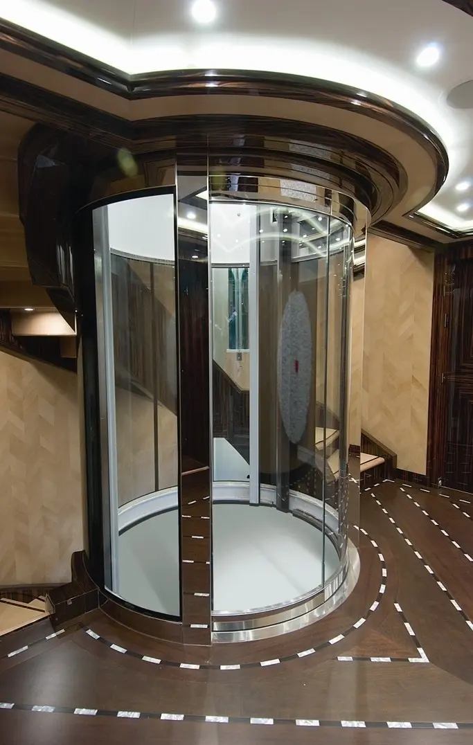 Glass-enclosed guest elevator in a round stairwell