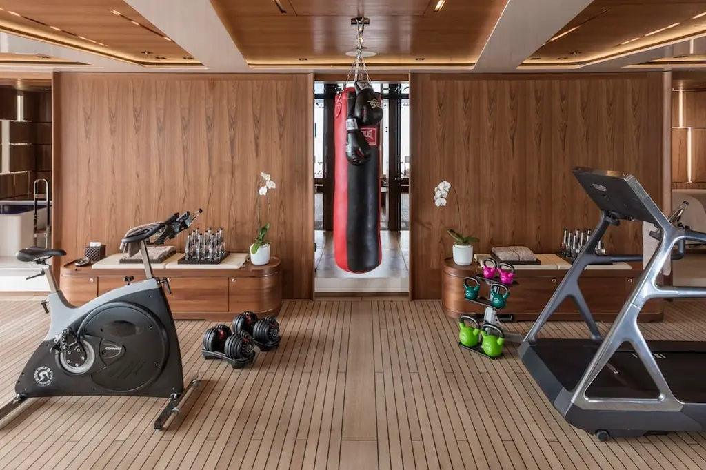 A gym with timber walls, an exercise bike, a treadmill and a punch bag