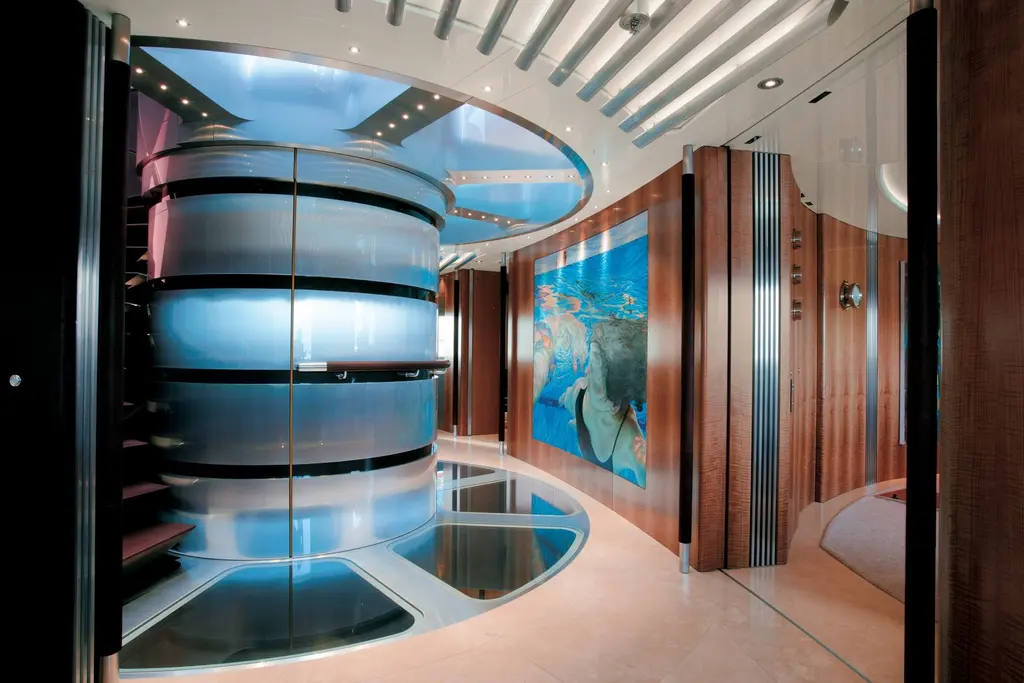 Lobby with a curved glass-and-steel stair tower and a large swimming-themed artwork
