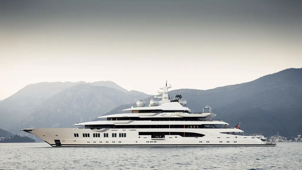 Amadea at anchor in profile in front of grey mountains