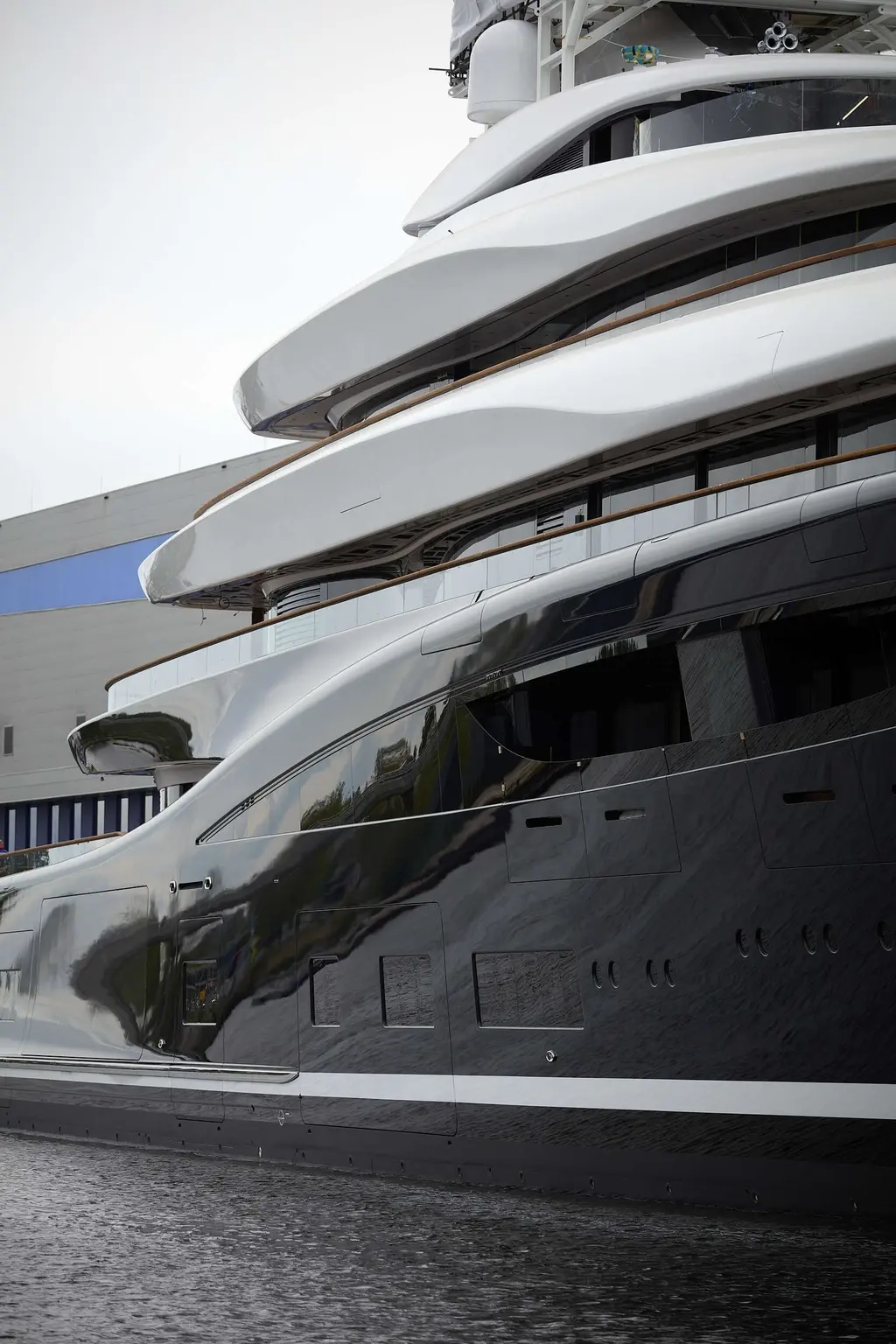 Close view of the curved white superstructure decks and glossy navy hull side of Breakthrough