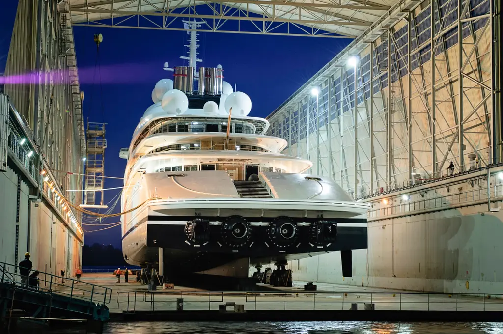Azzam's stern in the floating dock at night, with the waterjet outlets visible below the transom