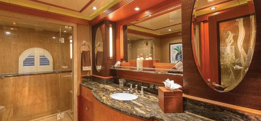 Bathroom with a dark granite counter, a glass shower and an etched mirror