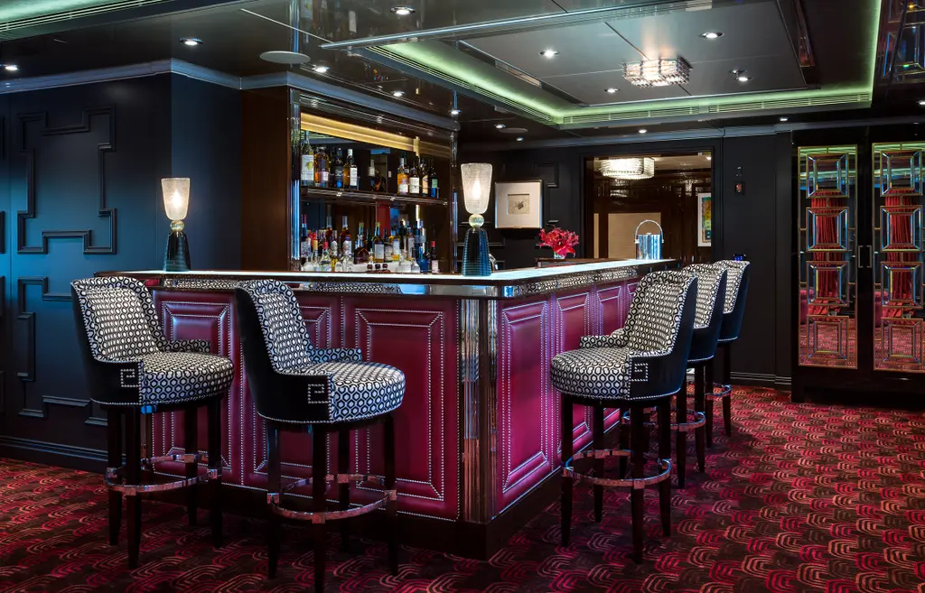 Bar with a plum lacquer front, patterned stools and patterned red carpet