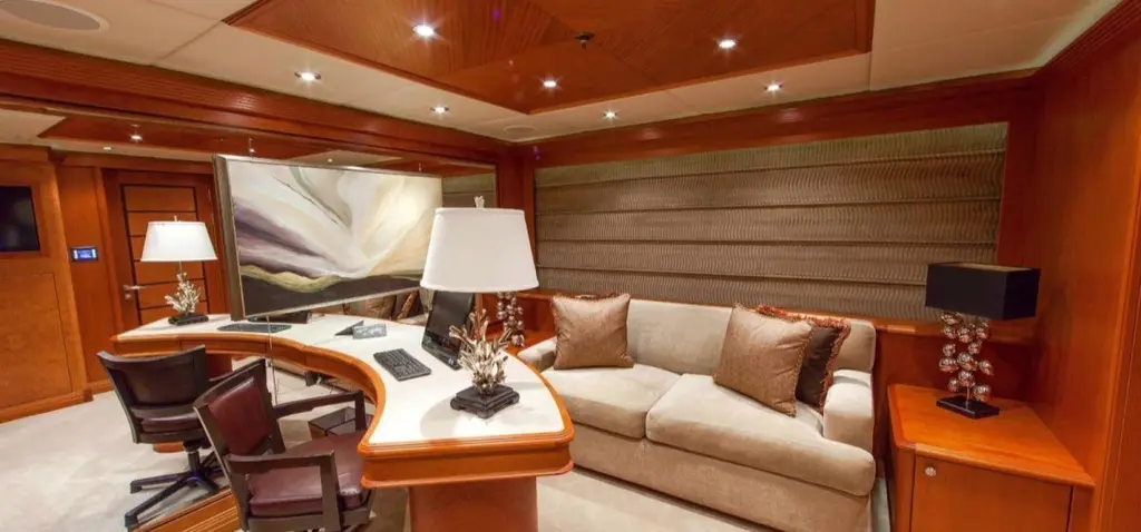 Study with a curved desk, a sofa and wood panelling