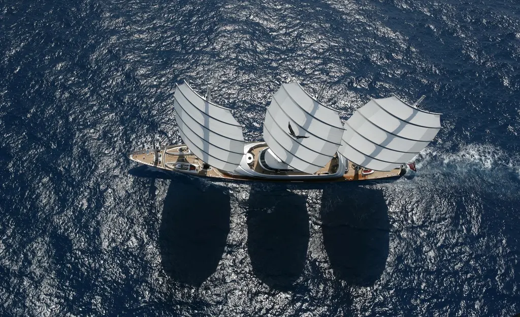 Maltese Falcon seen from directly above, three curved sails casting long shadows on the sea