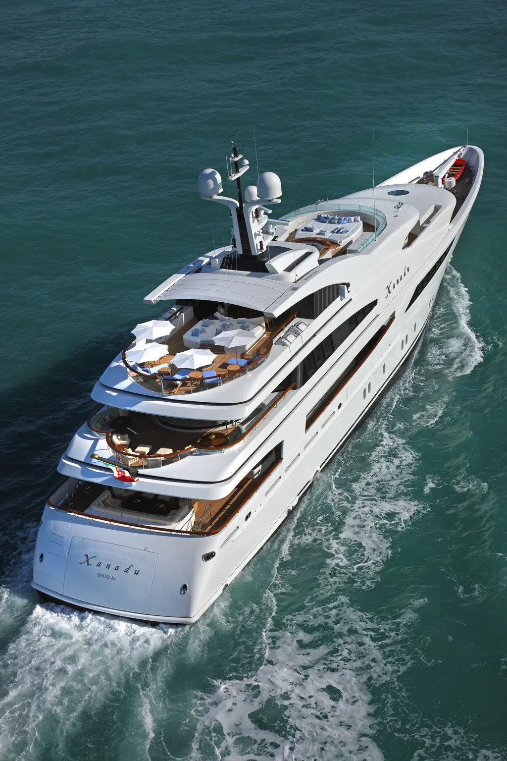 Aerial view of the yacht underway from the stern quarter, showing the stacked aft decks