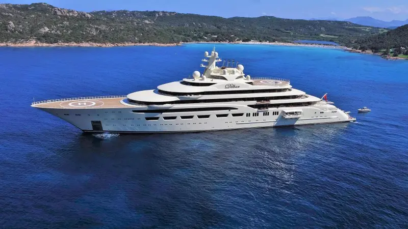 Dilbar at anchor in a blue bay, seen from the air, helipad on the foredeck