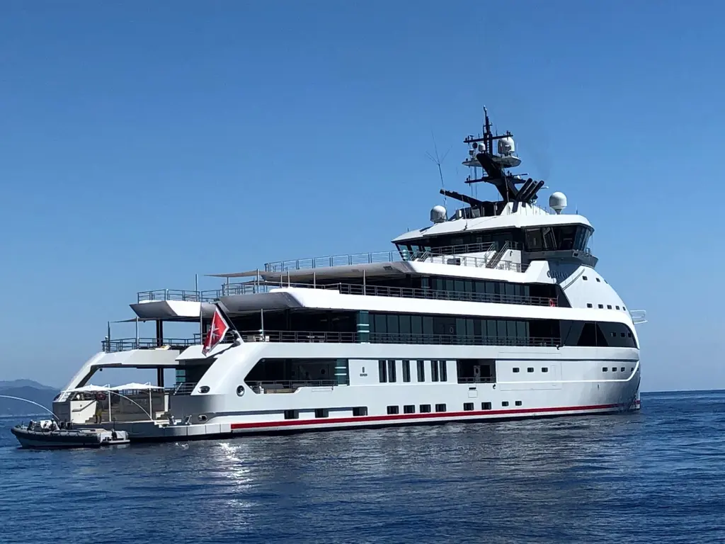 Olivia O from the starboard quarter: stepped aft decks, the low aft deck at the stern and a tender alongside