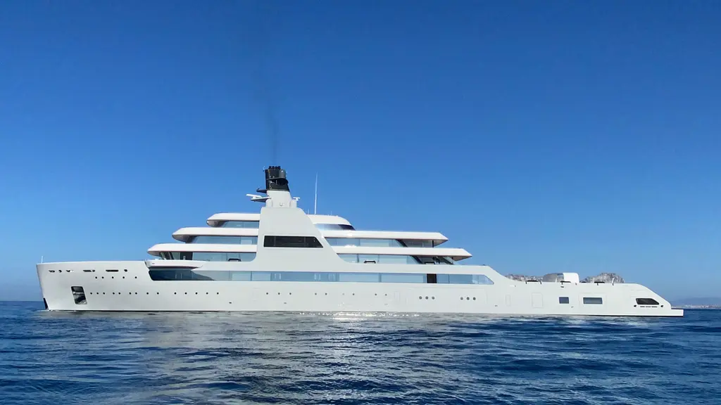 Solaris in full profile at sea under a clear blue sky, light grey hull and white superstructure
