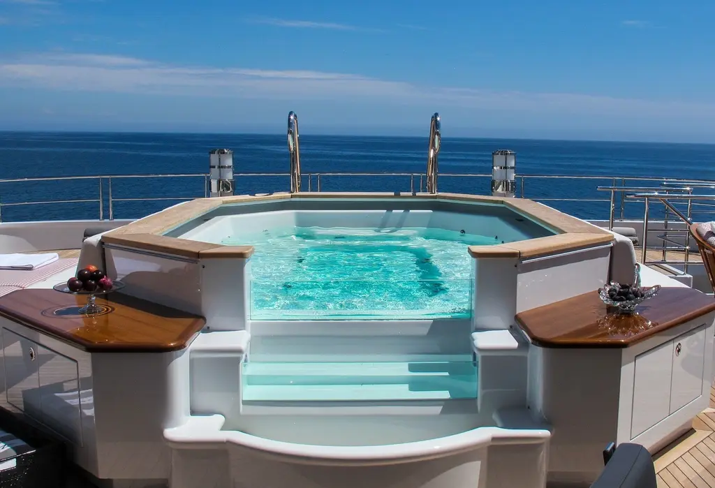 Spa pool on the sundeck, with wood-topped counters on both sides and open sea behind