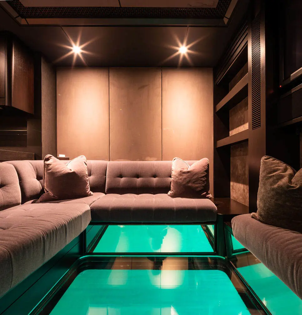 Dark lounge with a sofa around an illuminated glass floor