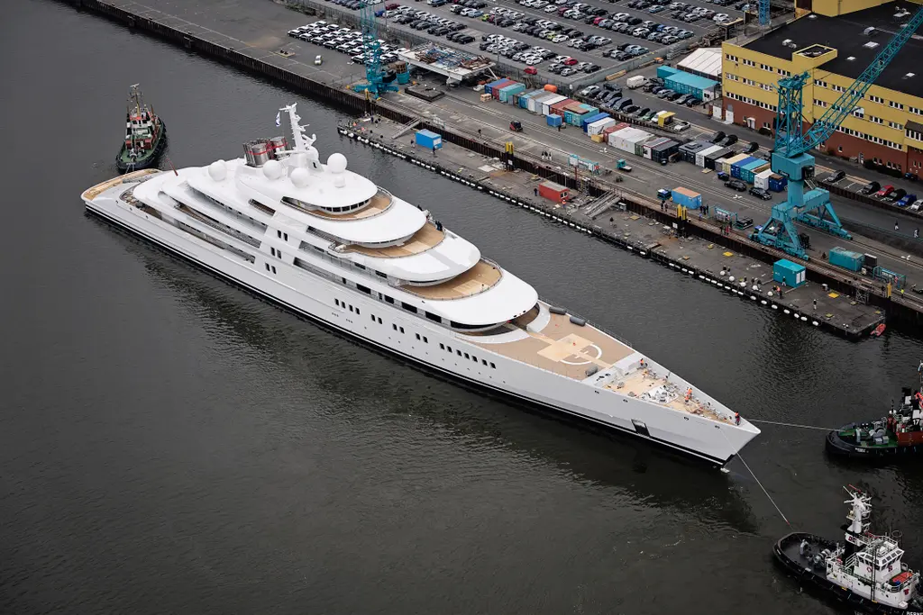Aerial view of Azzam from the bow, showing the helipad on the foredeck and tugs alongside